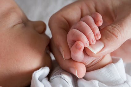 newborn baby unisex girl boy holding hand mom mother parent family